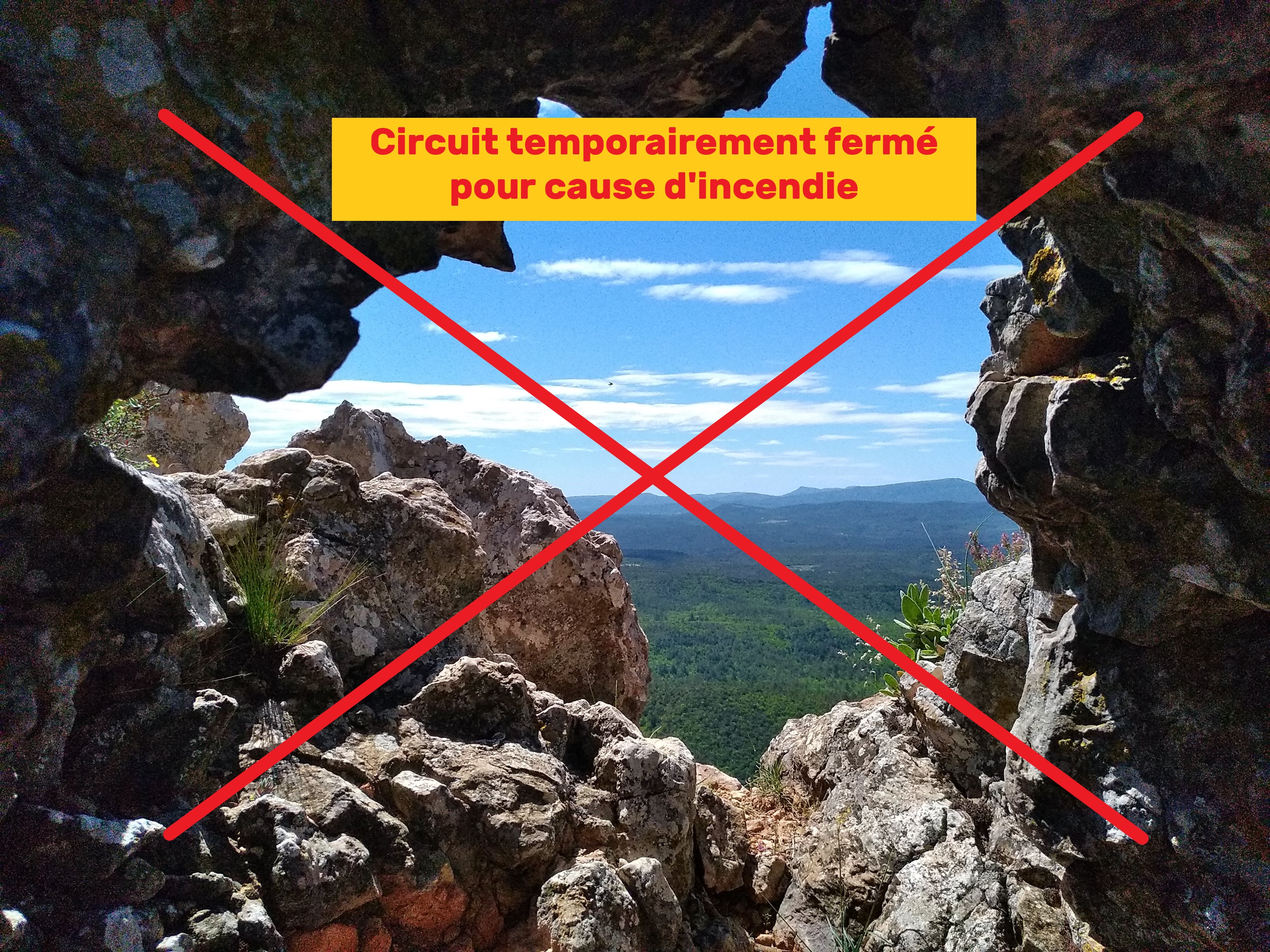 Panorama sur la forêt et les sommets lointain à travers des pierres formant un trou